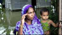Mãe e filho em uma casa alagada em Bangladesh (foto: Shawn/Flickr)