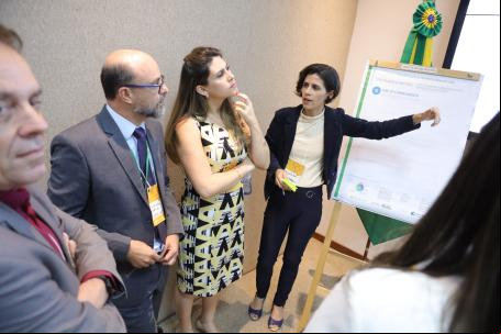 mulhr aponta para cartaz com informações sobre projeto